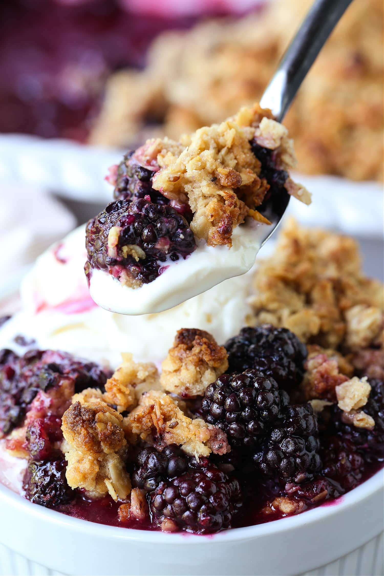 blackberry crisp on a spoon with ice cream