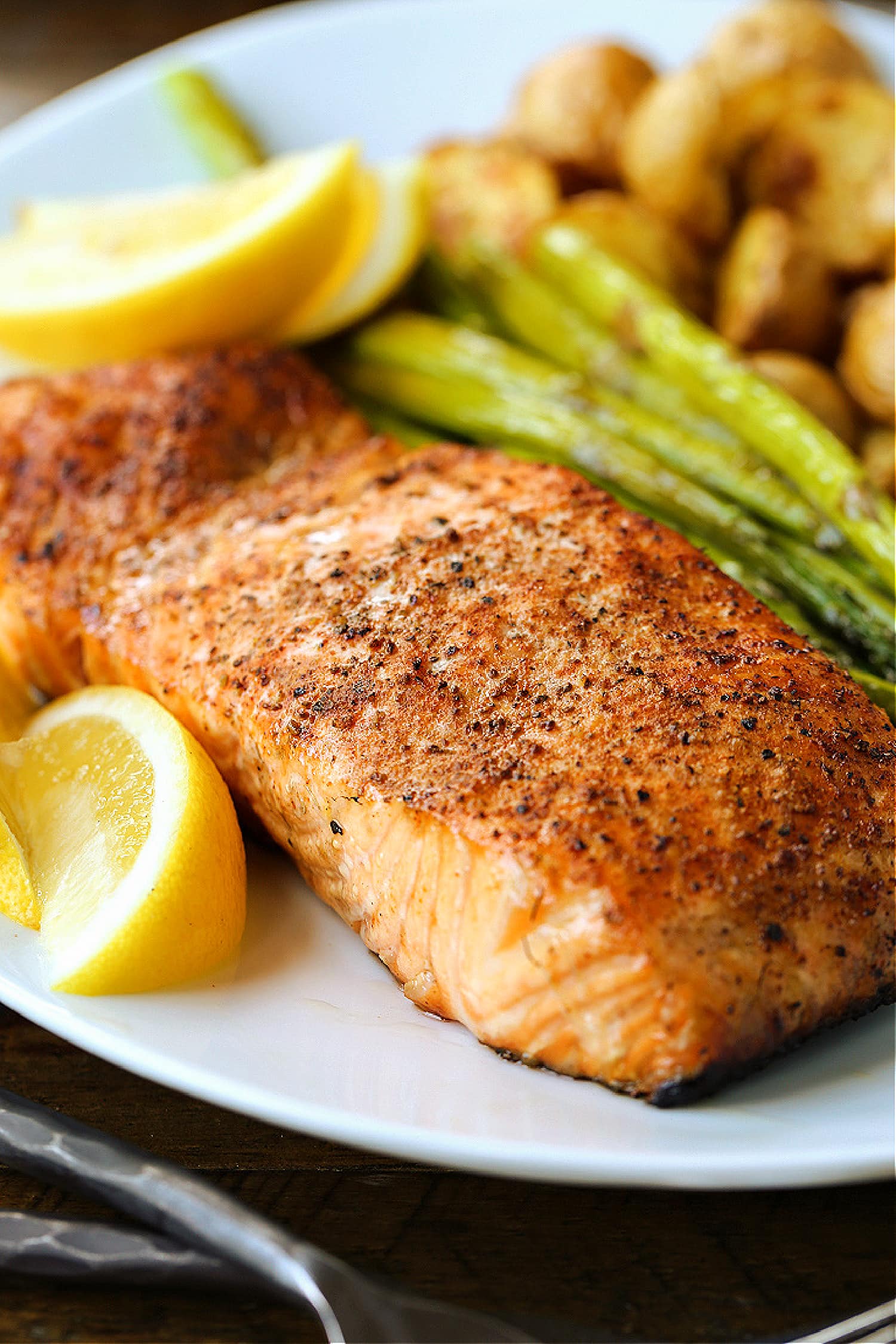 This Easy Grilled Salmon Recipe is the perfect summer dinner! A healthy seafood meal that you can have on the table in 15 minutes! salmon filet on plate with vegetables