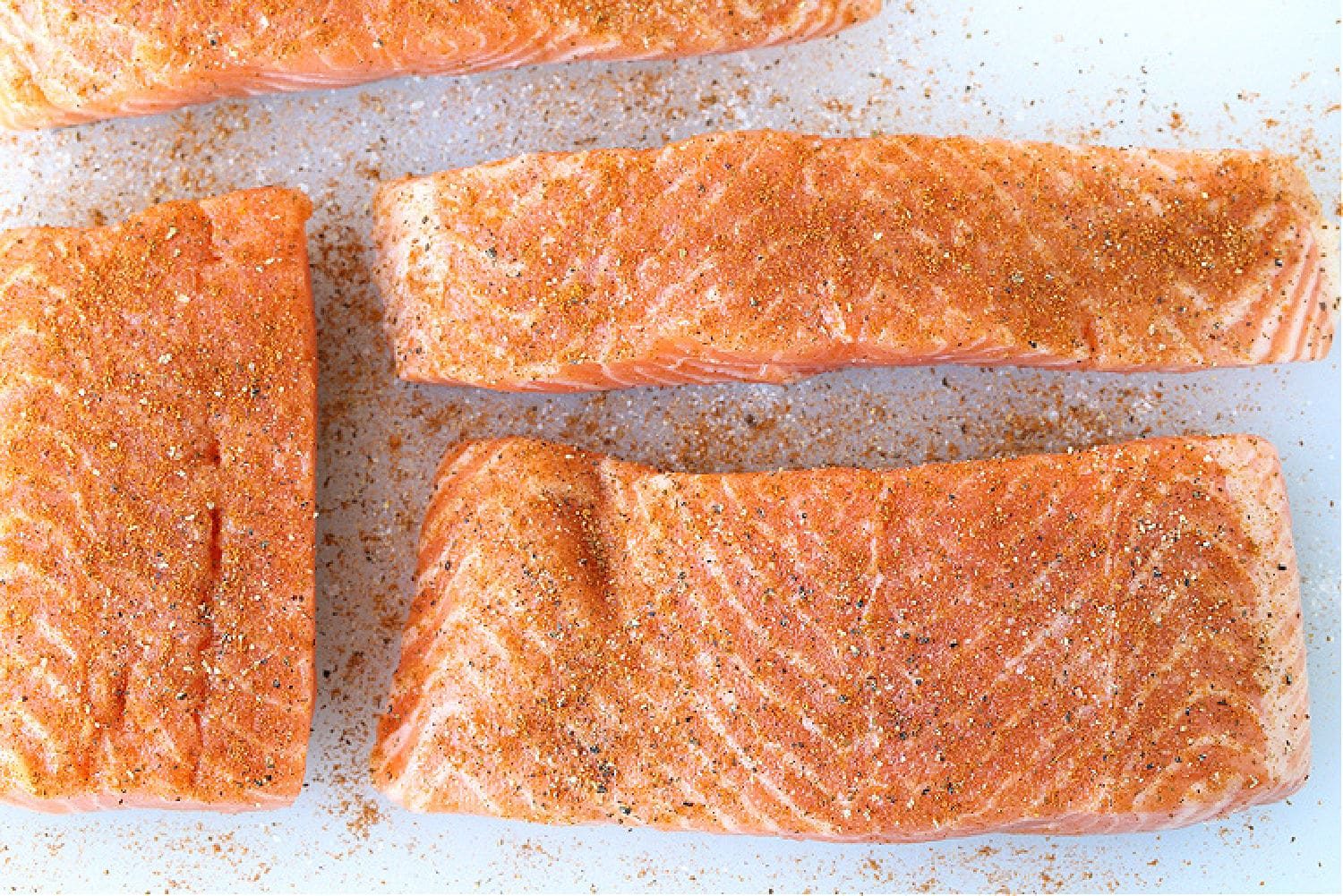 This Easy Grilled Salmon Recipe is the perfect summer dinner! A healthy seafood meal that you can have on the table in 15 minutes! salmon filets on board with seasoning