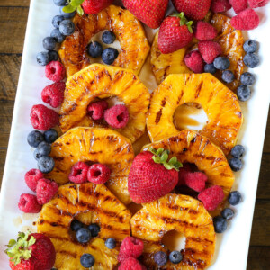 grilled pineapple on a platter with berries
