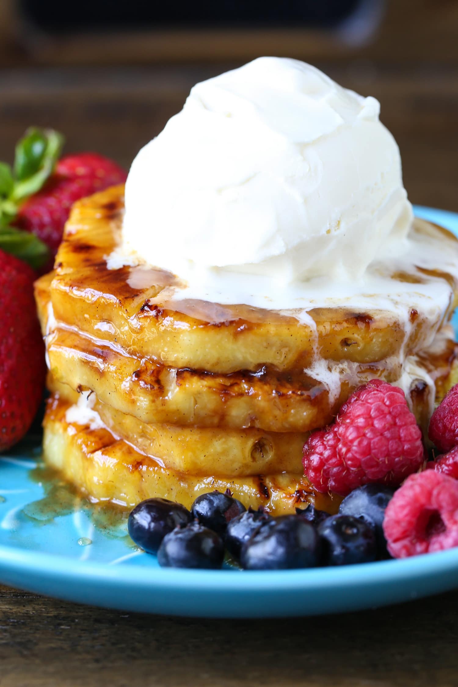 grilled pineapple on blue plate with ice cream