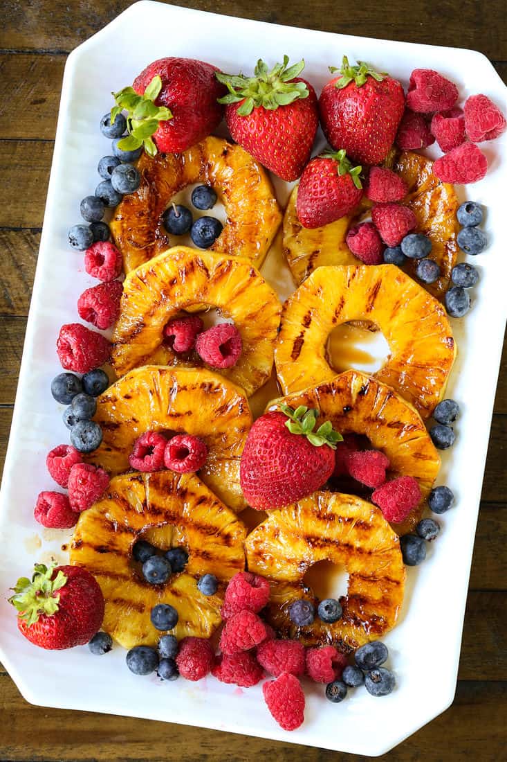 grilled pineapple with fresh berries on a platter