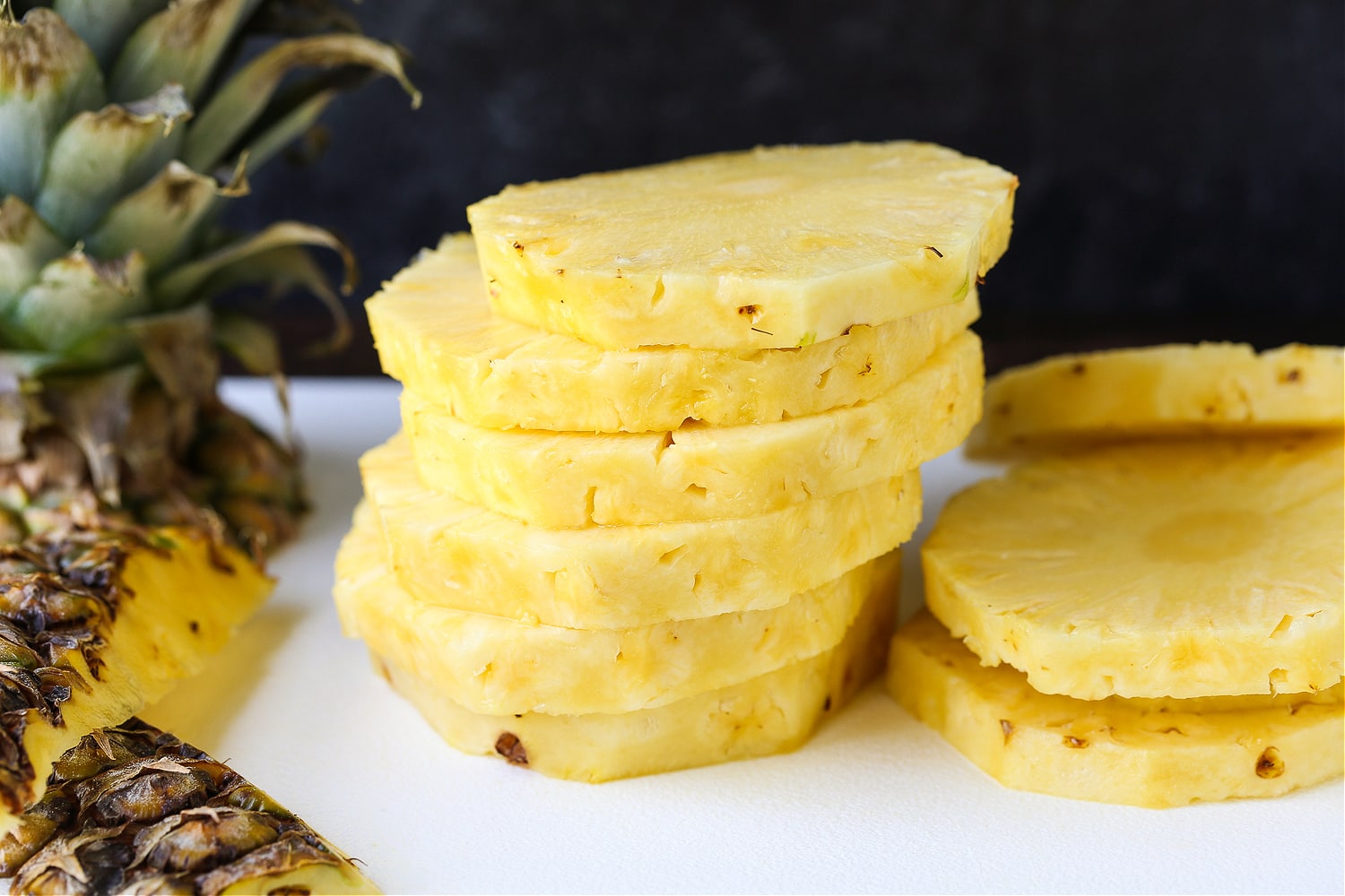 sliced, stacked pineapple on a board