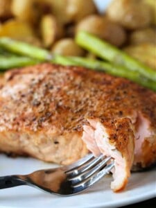 grilled salmon recipe on a plate with fork bite