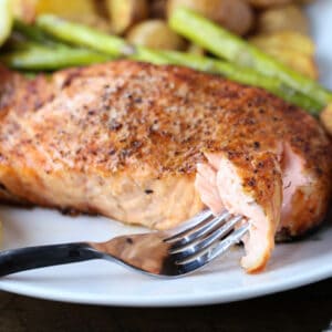 grilled salmon recipe on a plate with fork bite