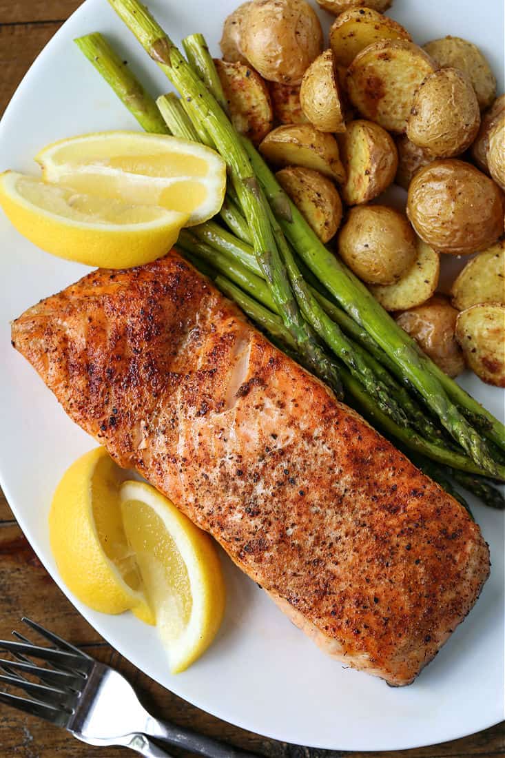 salmon filet on a plate with potatoes and asparagus