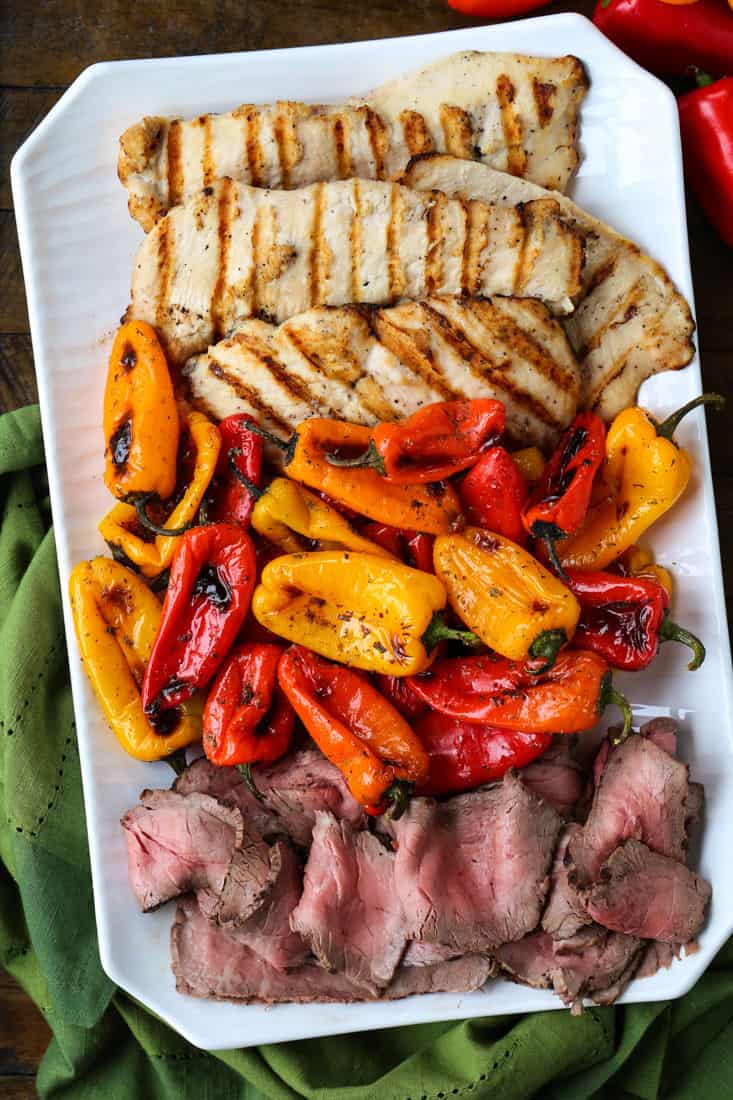 mini roasted peppers on a platter with steak and chicken