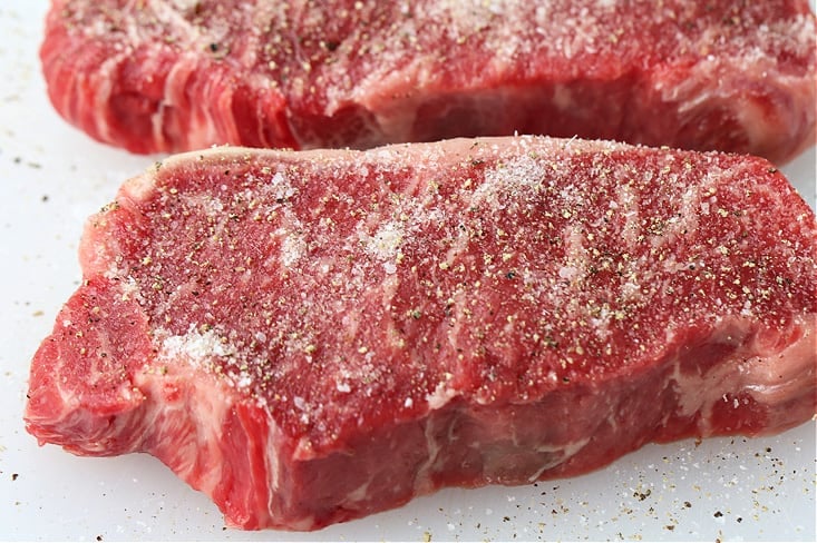 new york strip steaks seasoned with salt and pepper