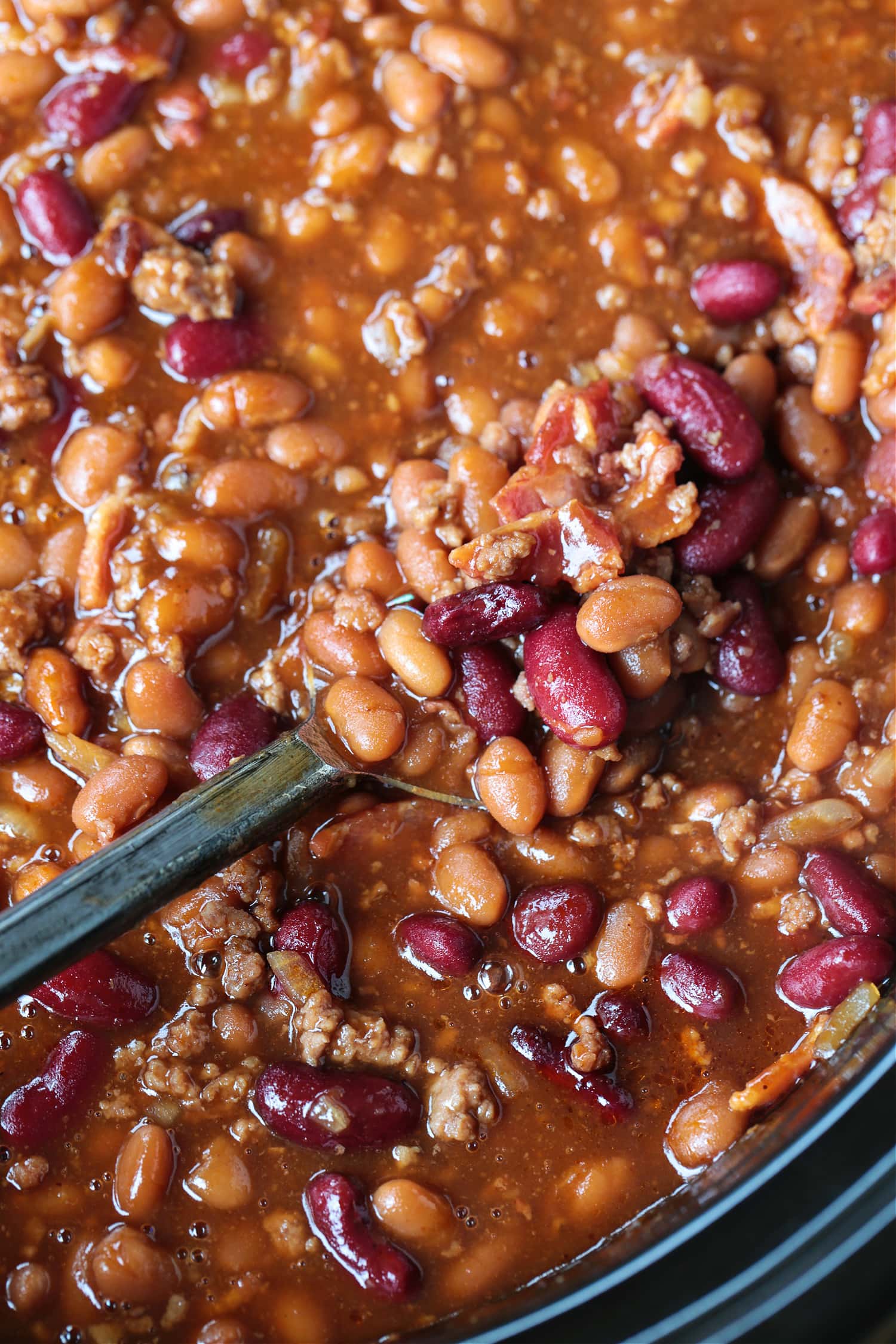slow cooker baked beans on a spoon