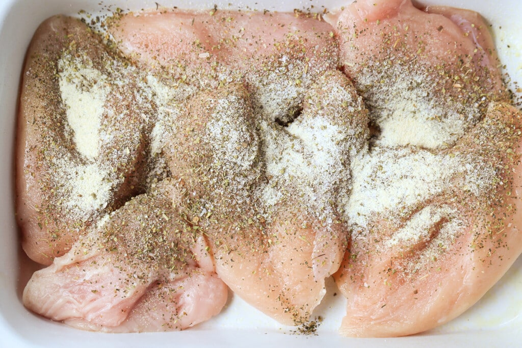 Slow Cooker Chicken Parmesan Sandwiches are an easy dinner for any night of the week! Perfect for meal prepping, game days or holidays! chicken breasts in slow cooker with seasonings