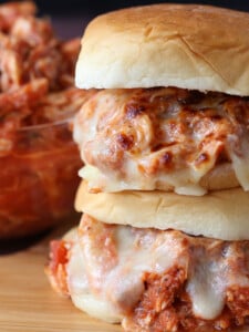 stacked sandwiches with shredded chicken and melted mozzarella cheese