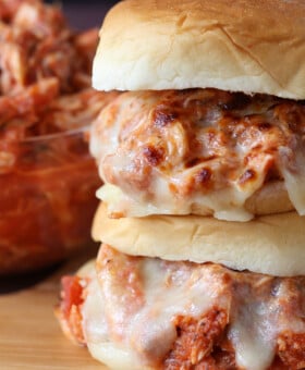 stacked sandwiches with shredded chicken and melted mozzarella cheese