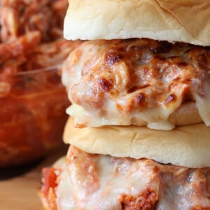 stacked sandwiches with shredded chicken and melted mozzarella cheese