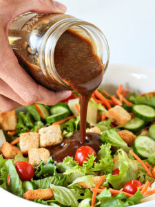 Creamy Balsamic dressing being poured over a salad
