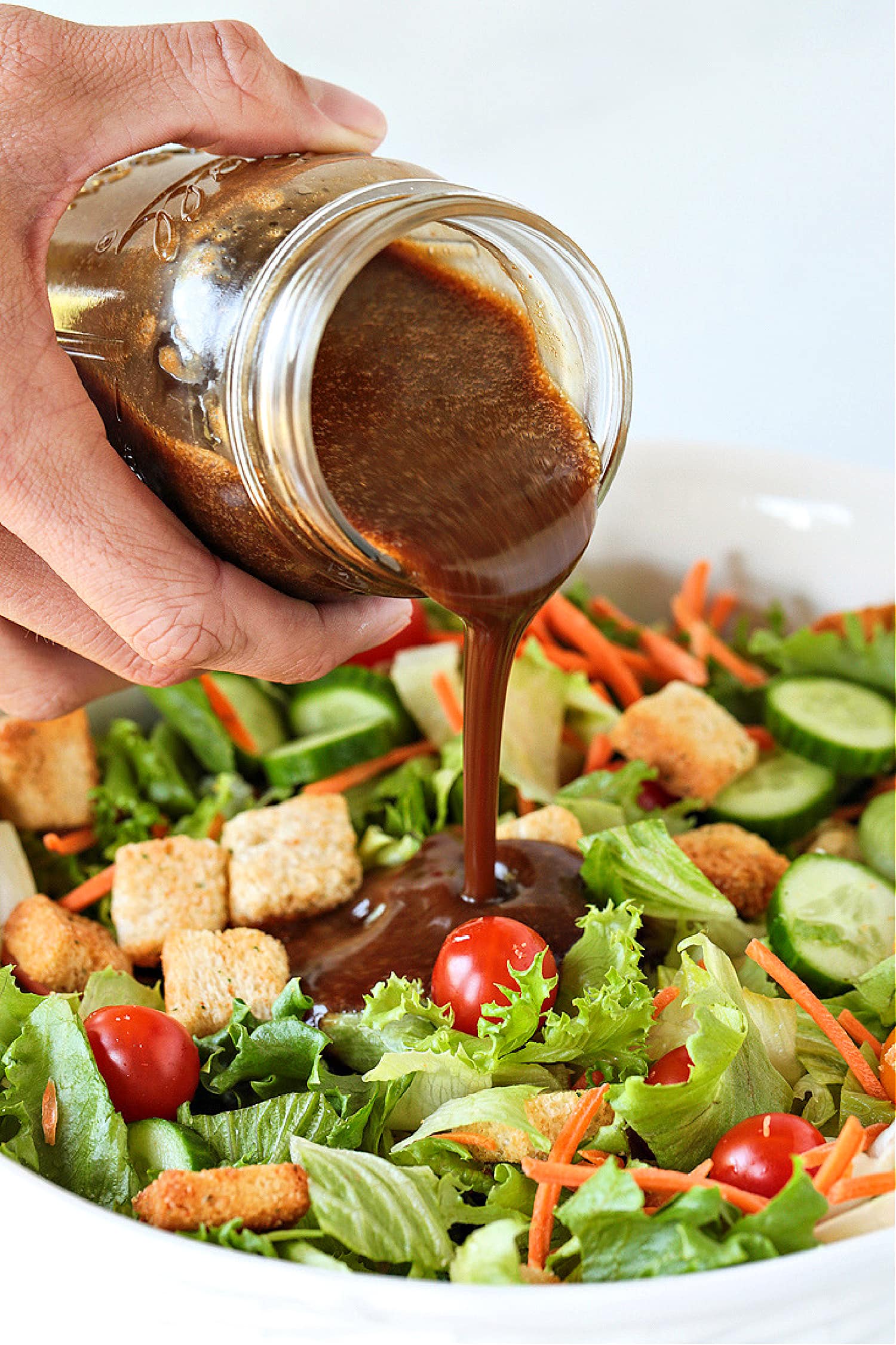 Creamy Balsamic dressing being poured over a salad