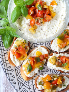 bruschetta with whipped feta on a black and white platter