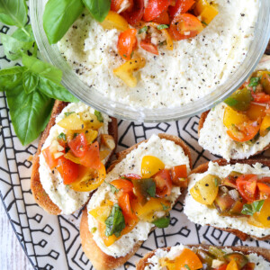 bruschetta with whipped feta on a black and white platter