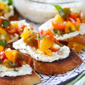 bruschetta with whipped feta spread on platter with basil