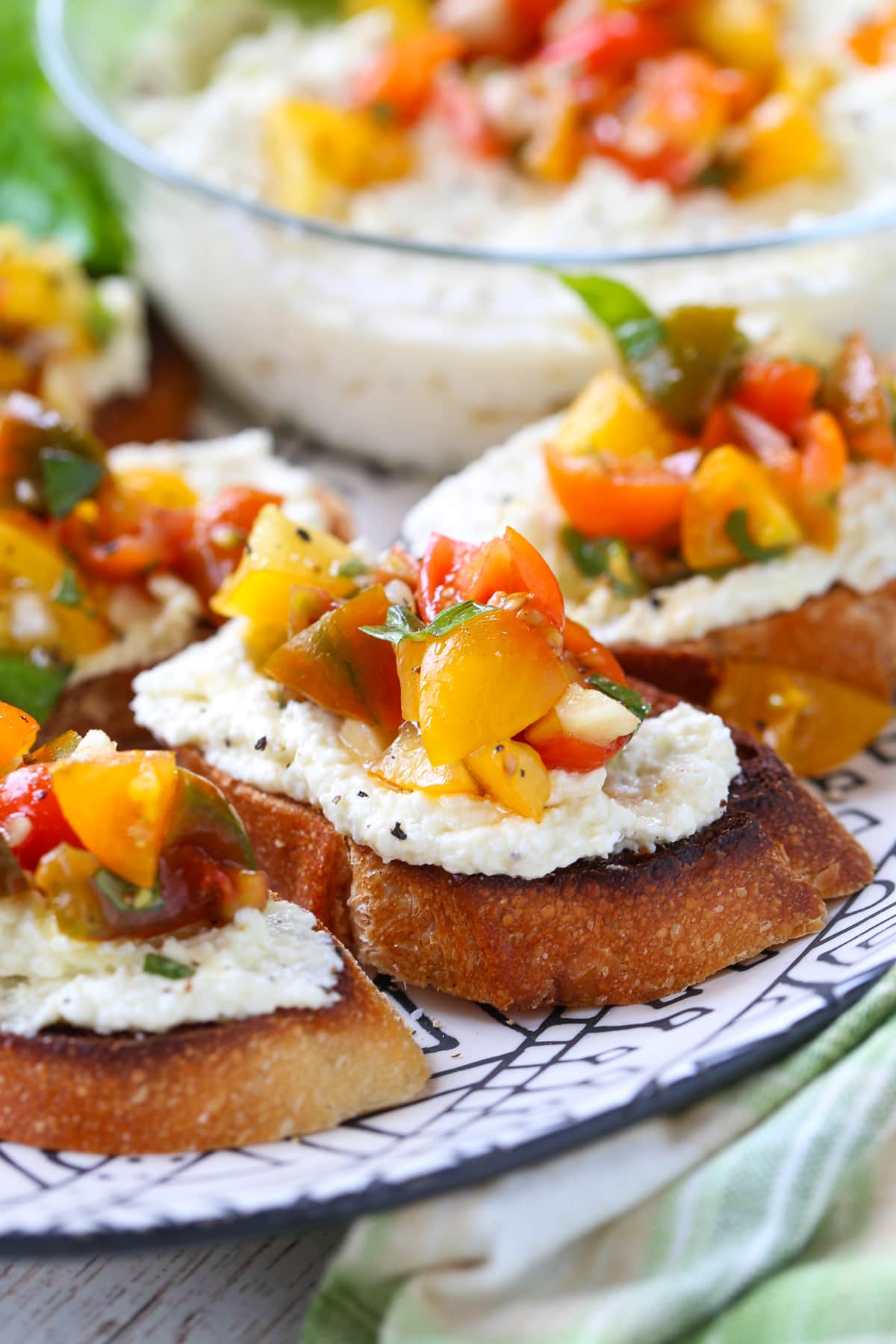 bruschetta with whipped feta spread on platter with basil