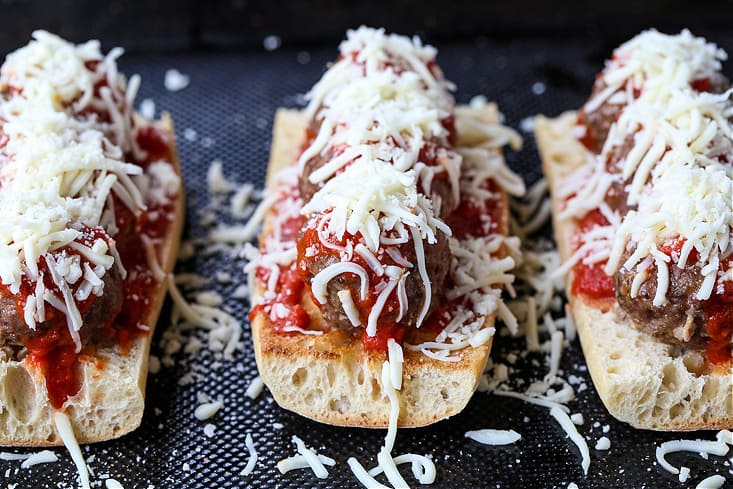 meatball parmesan subs on a baking sheet before going in the oven