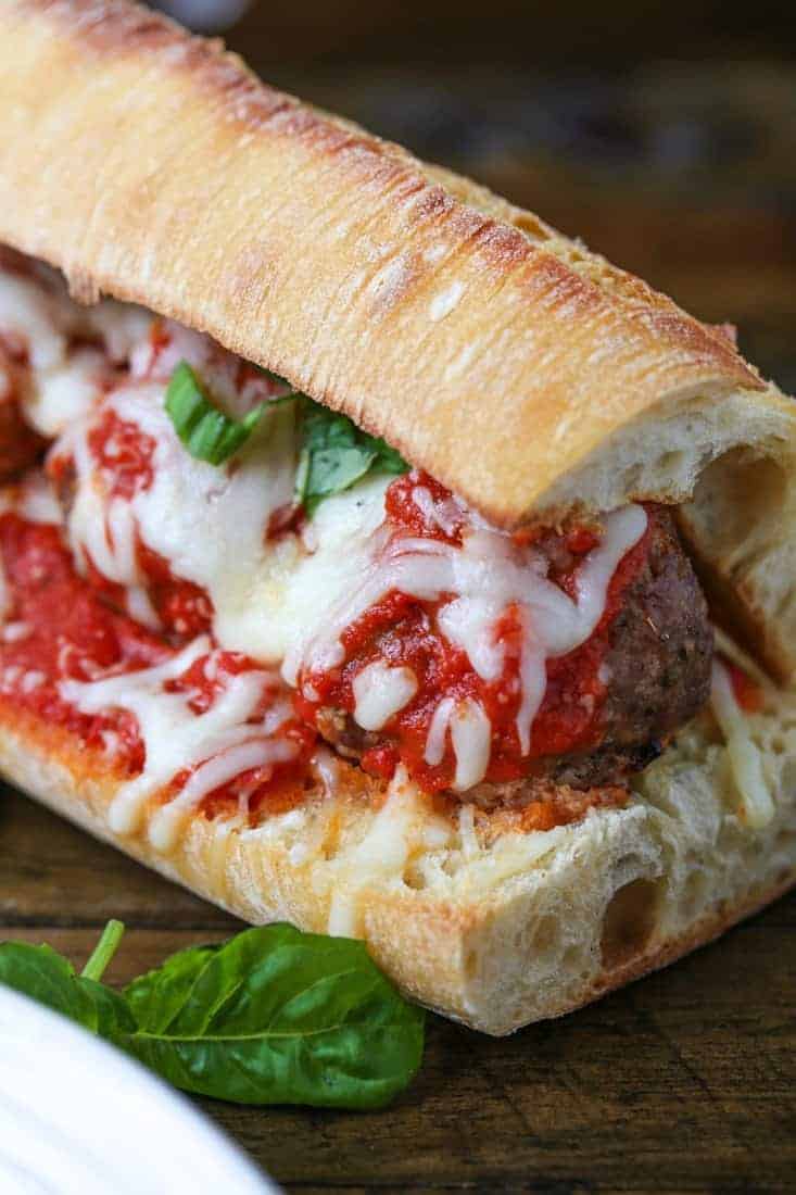 meatball sub on a board with fresh basil