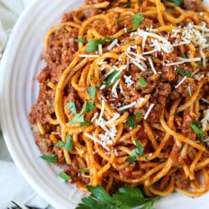 Spaghetti and beef recipe on a plate with fresh parsley