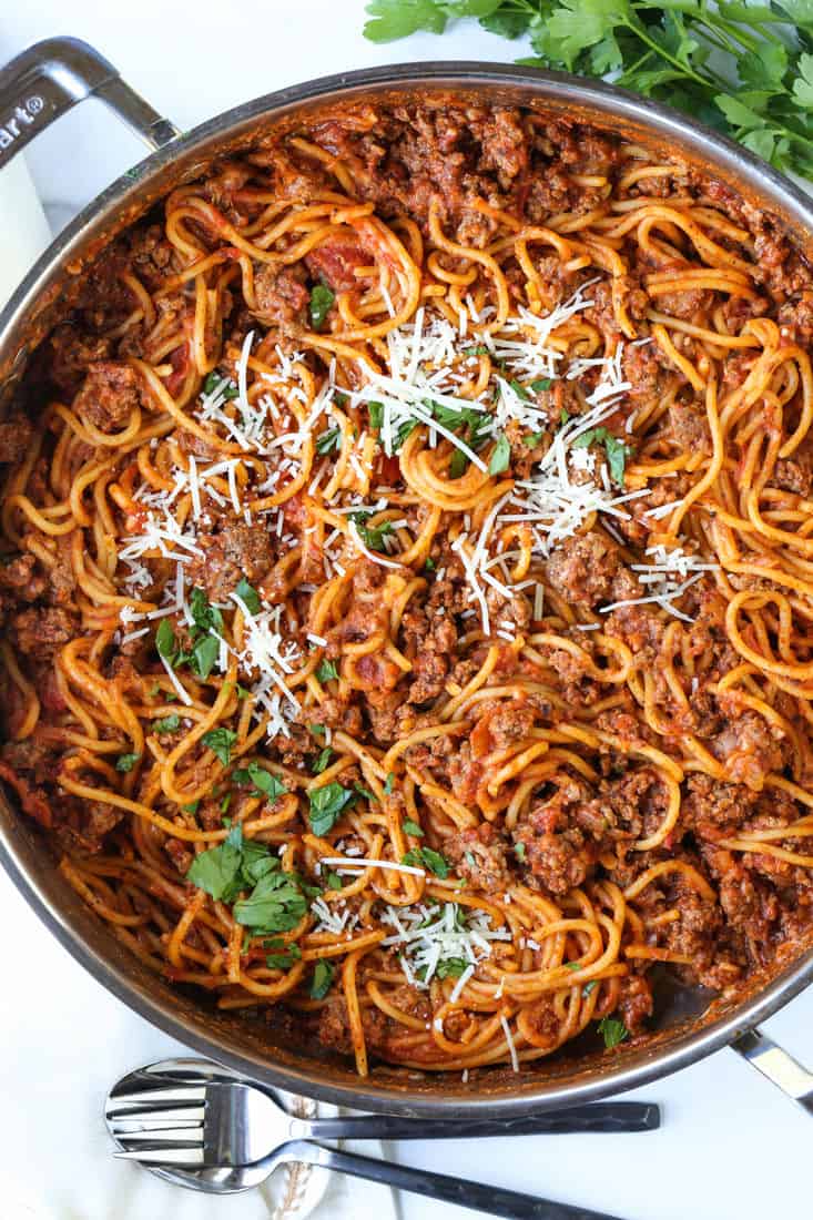 one pot spaghetti recipe in a skillet with fresh parsley