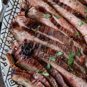 sliced teriyaki flank steak on a platter