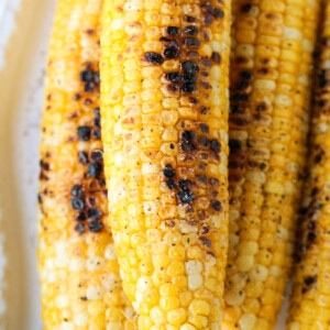 grilled corn on the cob on white platter