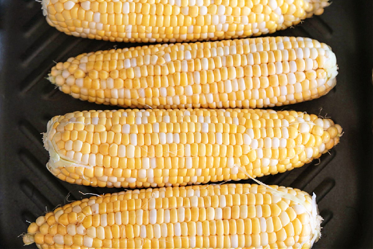 Corn on the Cob on the Grill is an easy and delicious way to make corn! Sweet corn with a charred flavor that makes the perfect summer side! raw corn on the cob on grill pan