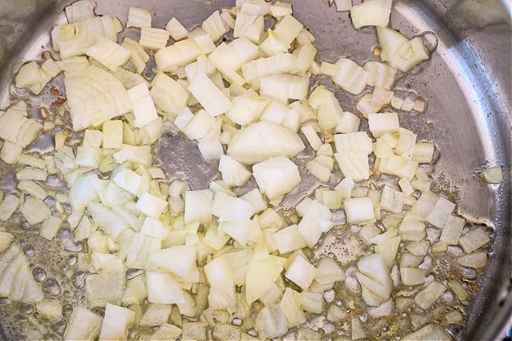 Cozy up to a bowl of this delicious Cream of Broccoli Soup! A nutritious soup recipe that gives you a luxurious, indulgent feel! onions cooking in a pot with butter