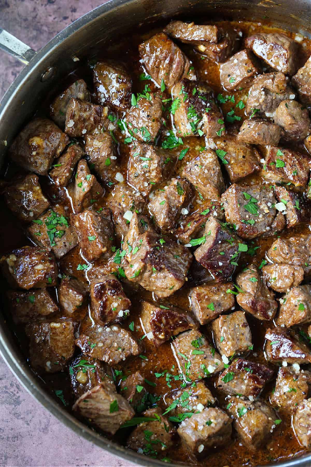 Sink your teeth into our Garlic Butter Steak Bites! Tender steak tossed in our famous garlic parmesan sauce, ready to eat in just 15 minutes! steak bites in skillet with garlic butter sauce