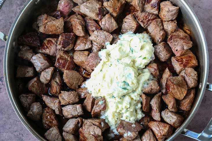 parmesan garlic butter sauce on top of seared steak bites