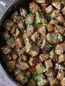 steak bites in a skillet with garlic parmesan sauce