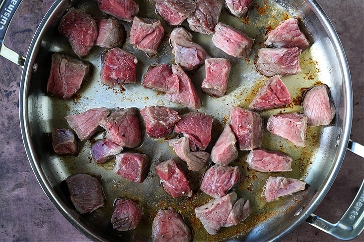 steak bites in a skillet with butter being seared