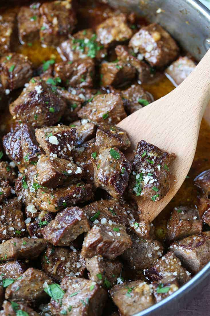 garlic parmesan steak bites in a skillet with spatula