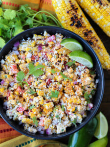 mexican street corn salad in a bowl with grilled corn on the side