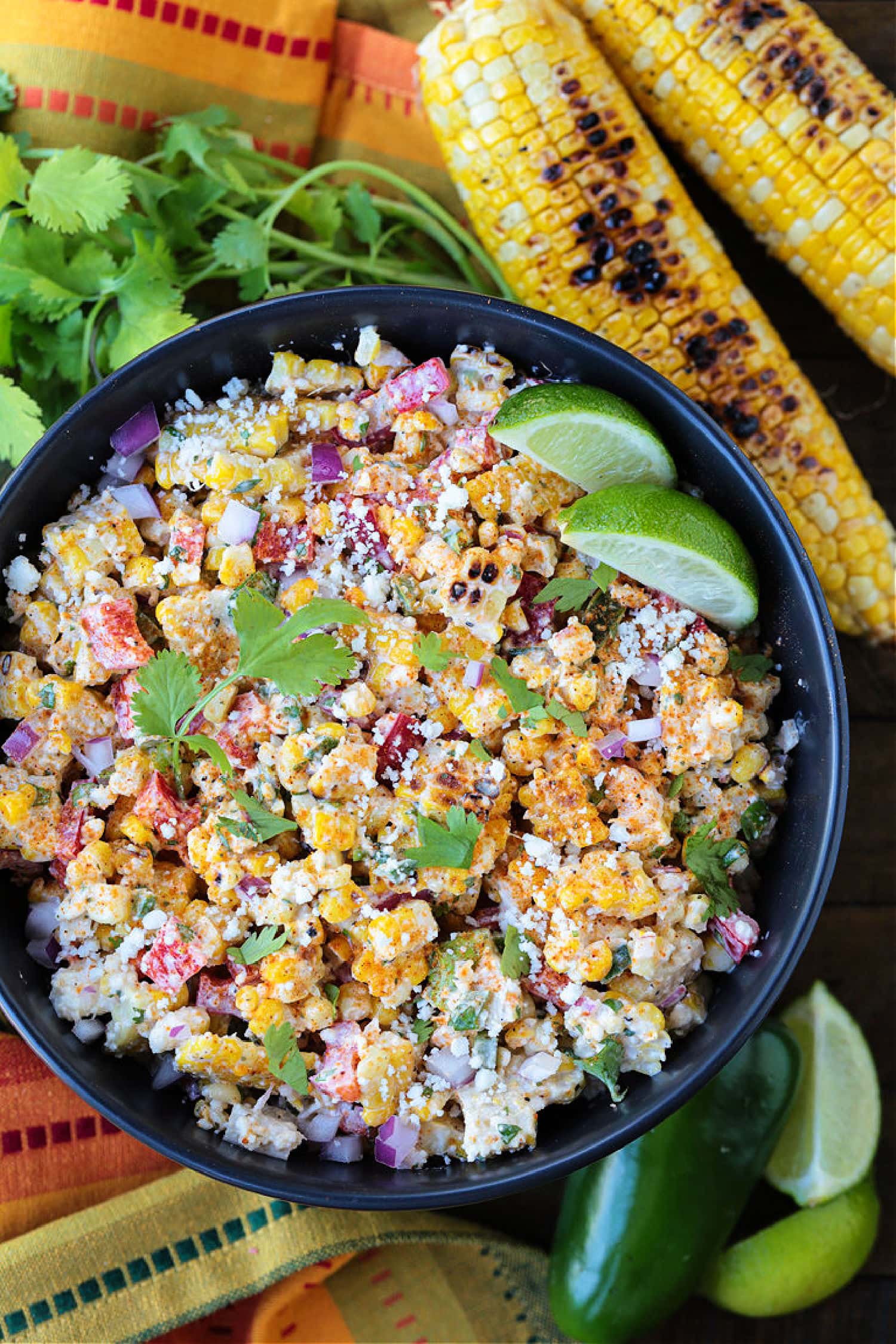 mexican street corn salad in a bowl with grilled corn on the side