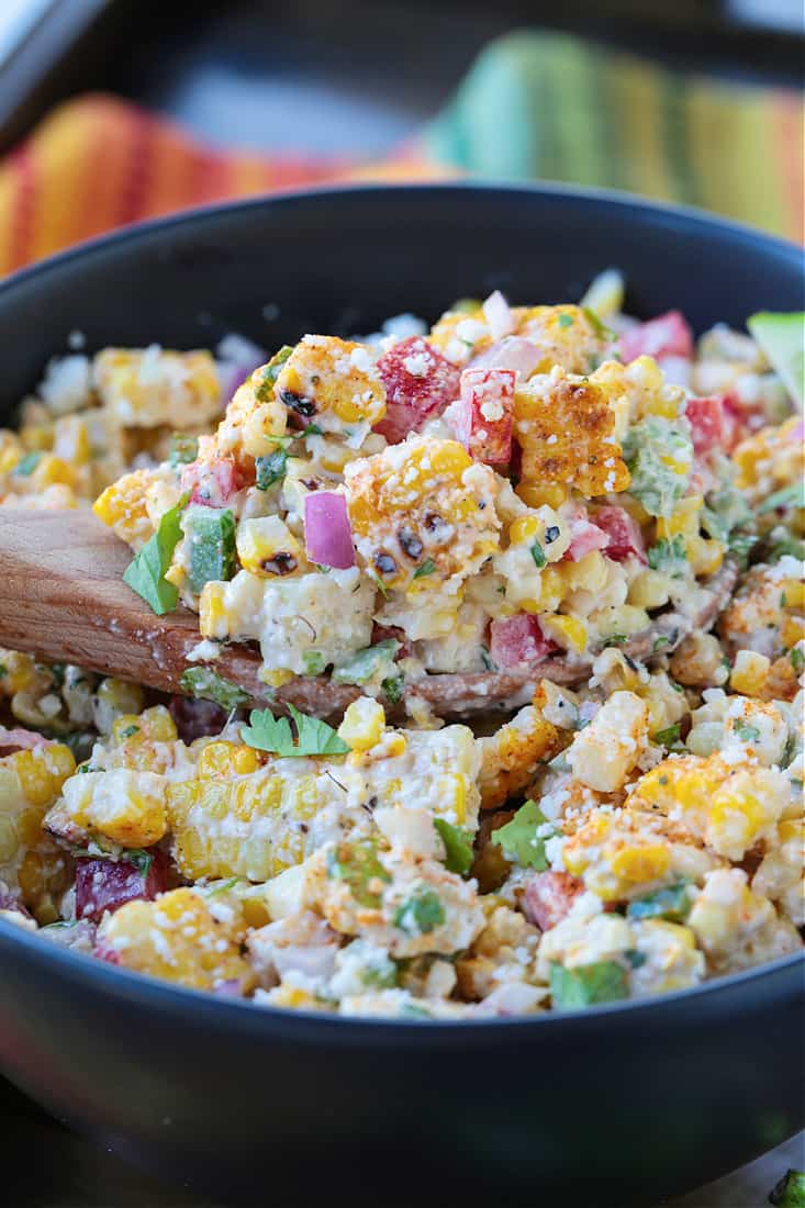 corn salad on a wooden spoon in a bowl