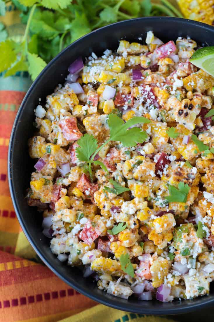 mexican street corn salad on a black bowl with napkin