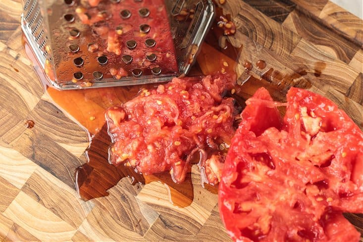 Grated tomato on a wooden cutting board