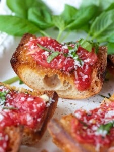 tomato bread on a plater with fresh basil