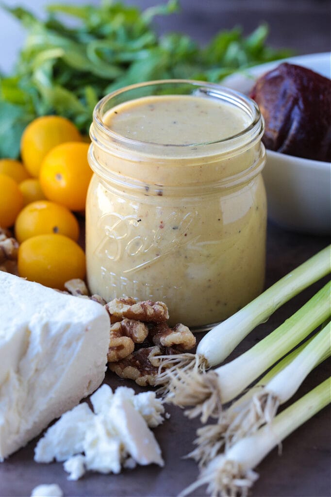 creamy maple salad dressing with fresh vegetables and feta cheese