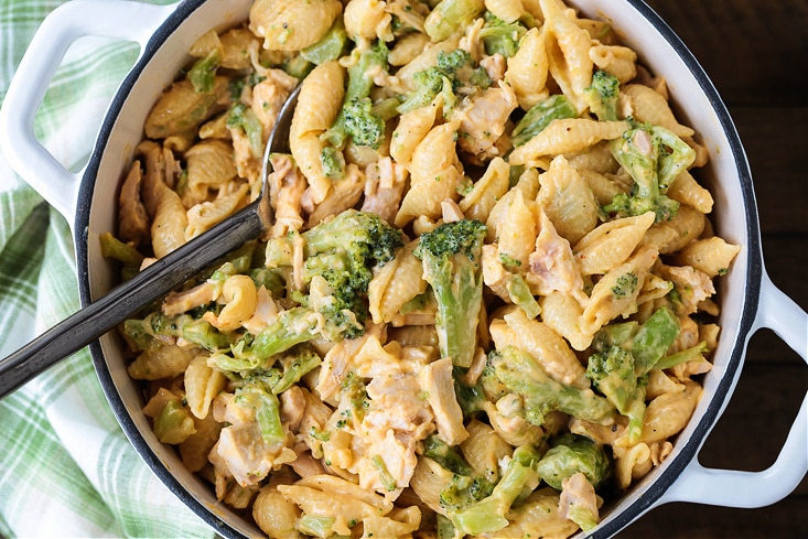 chicken broccoli pasta in a white pot with spoon