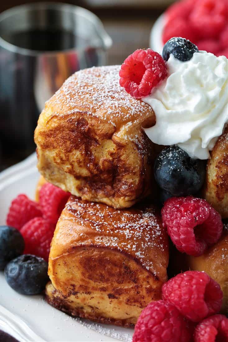 French toast recipe made with sweet rolls on a plate with whipped cream