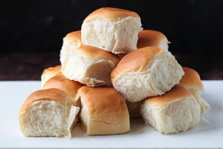 Hawaiian Rolls stacked on a cutting board