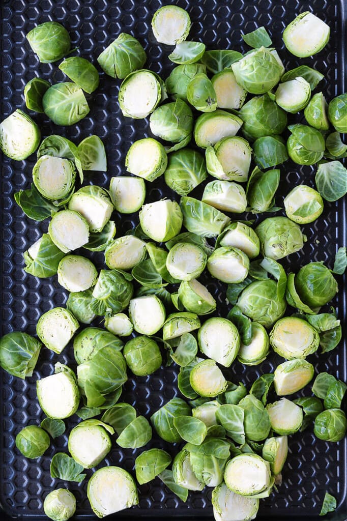 These Maple Bacon Brussels Sprouts have the perfect balance of sweet and salty! An easy to make, one pan vegetable side dish! sliced brussels sprouts on a sheet pan