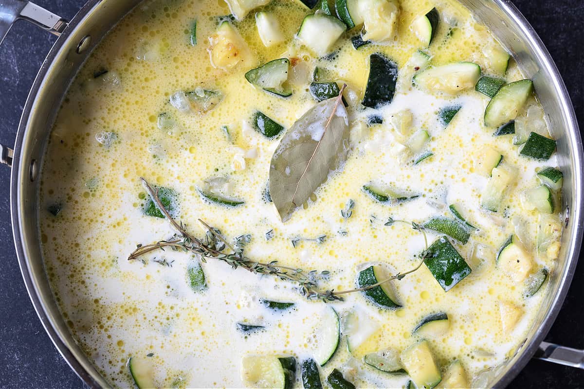 Zucchini Pasta Sauce can be used with any pasta shape, even in lasagna! Fresh and creamy and packed with tons of fresh zucchini flavor! Cream, herbs and zucchini in a skillet for making homemade sauce