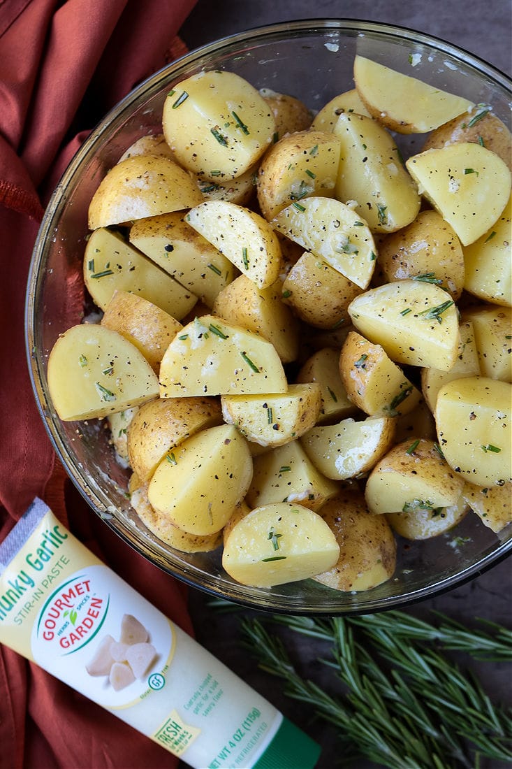 These Air Fryer Baby Potatoes are so crispy on the outside and tender and fluffy on the inside! A 15 minute, healthy side dish! baby potatoes in a bowl with rosemary, olive oil and garlic