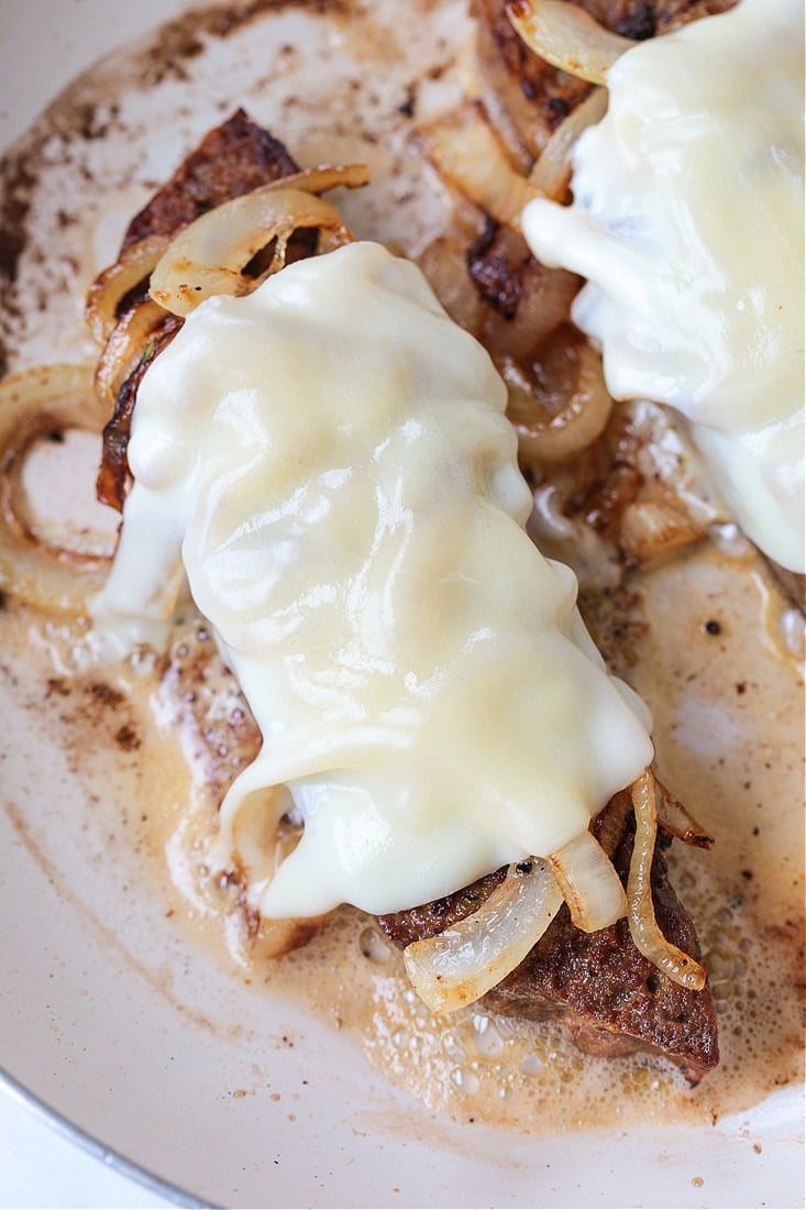 melted provolone cheese and onions on a slice of meatloaf